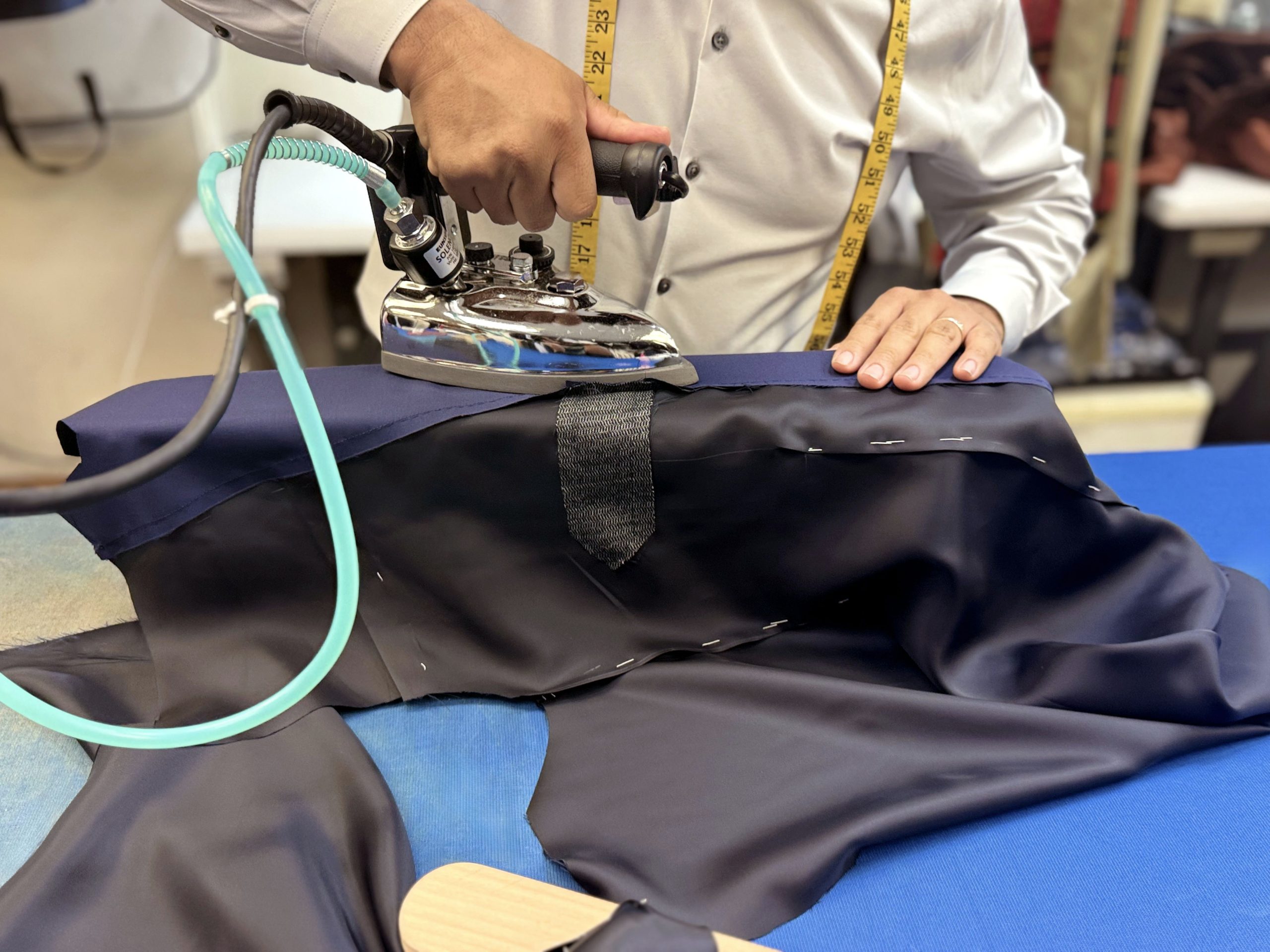 Bhambi's master tailor hand-sewing a bespoke suit in the New York City workshop – custom menswear crafted in Midtown Manhattan